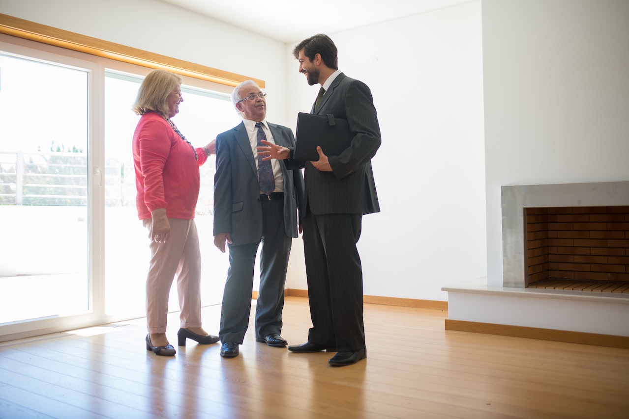 a real estate agent talking and showing a house to a couple